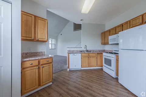 A kitchen with wooden cabinets and white appliances.
