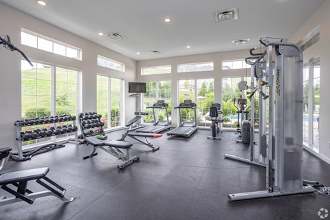 A spacious gym with a variety of equipment and a view of the outdoors.