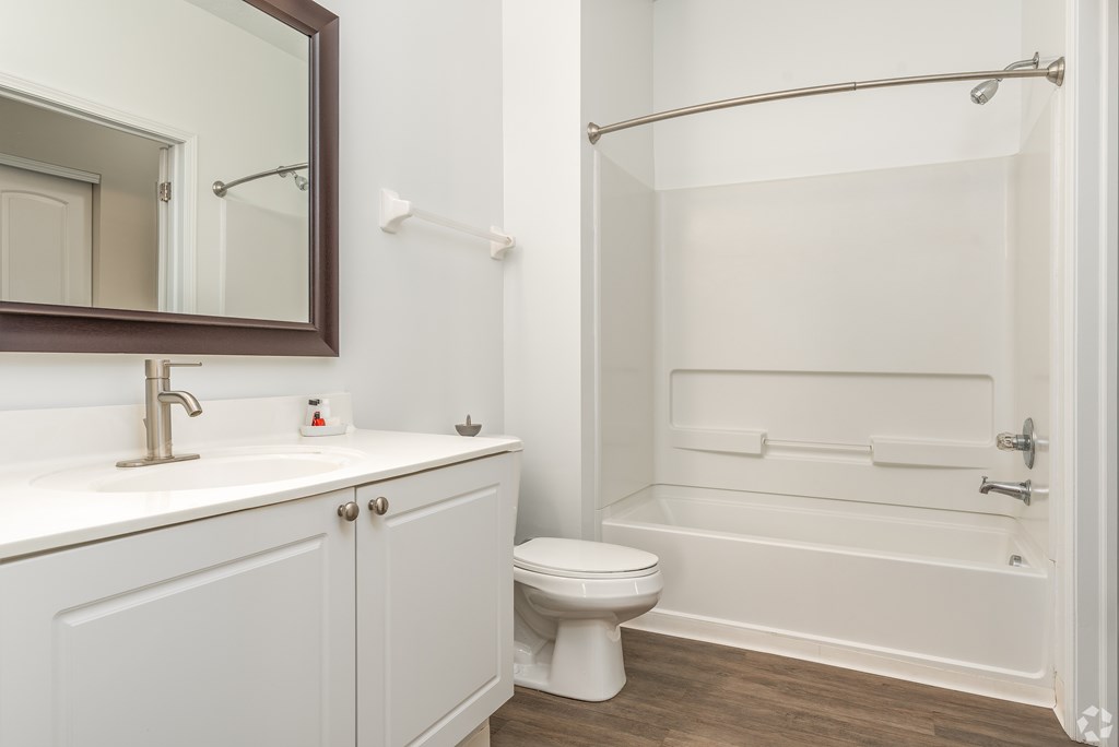 A white bathroom with a toilet, sink, and bathtub.