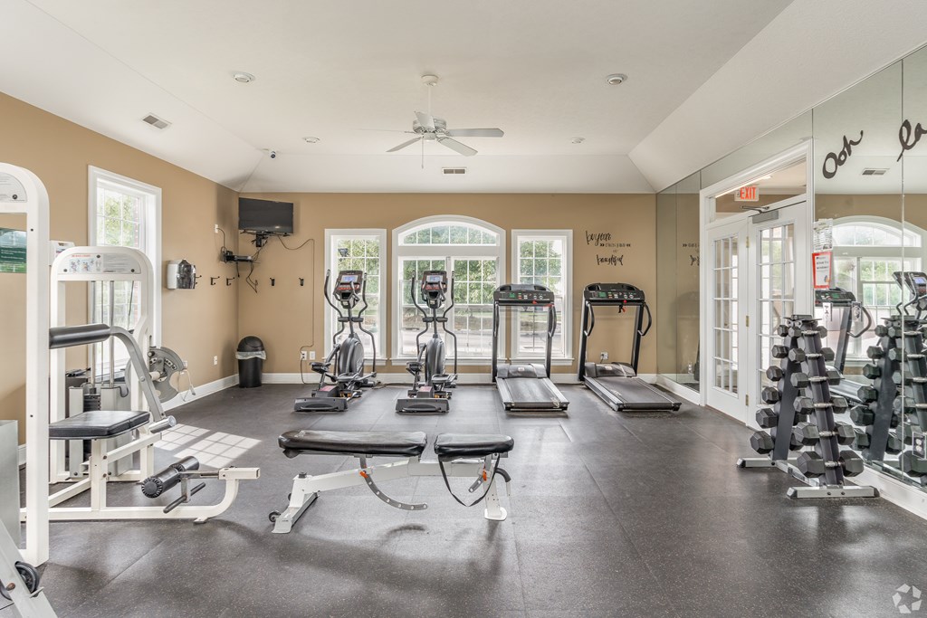 A spacious gym with a variety of equipment including treadmills, weights, and exercise machines.