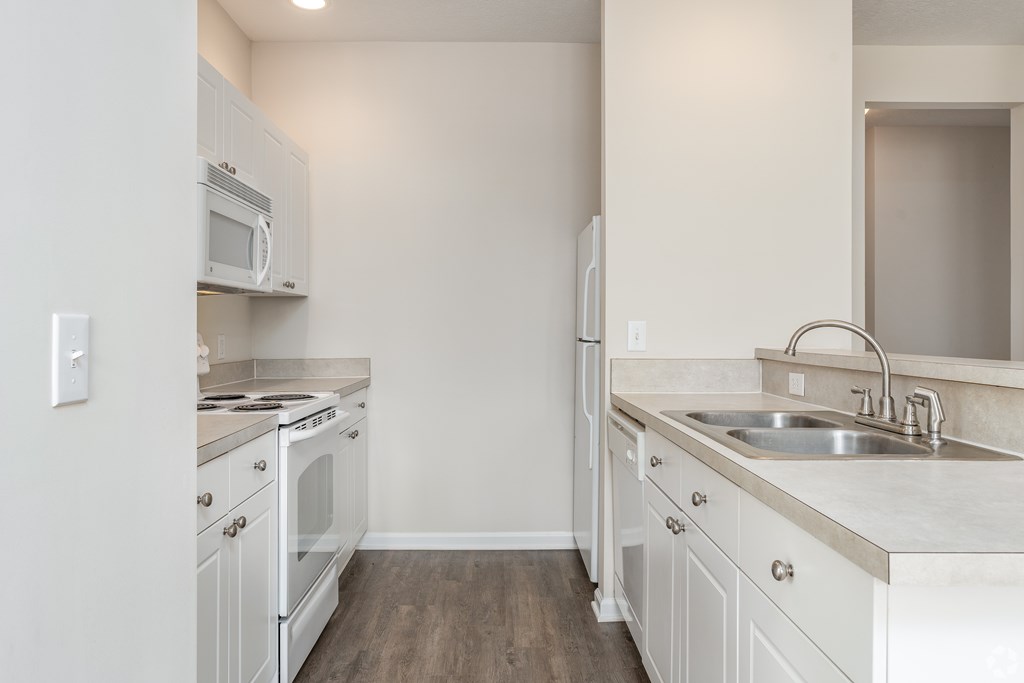 A kitchen with white cabinets and a stainless steel stove top.