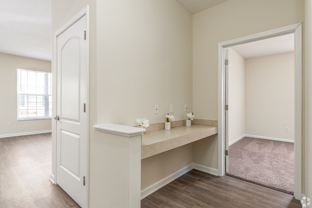 A room with a white door and a vanity table with a mirror and lights.
