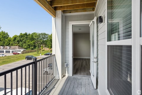 A white house with a wooden deck and a glass door.