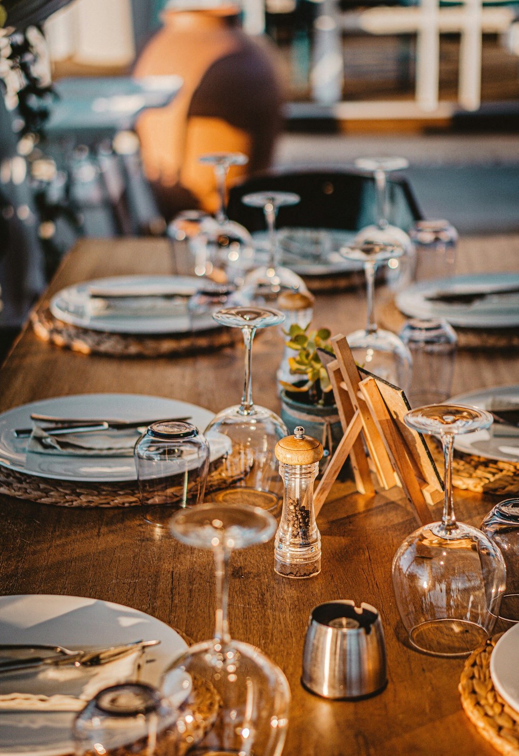 a wooden table with plates and glasses on it at Imperial Crossing Luxury Apartment Homes, Bonita Springs, Florida