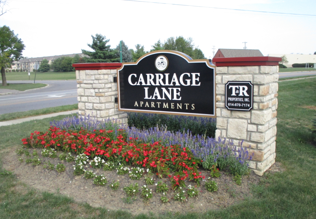 the sign for the carriage lane apartments on the side of the road