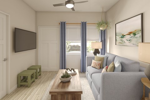 A living room with a grey couch, a wooden coffee table, and a flat screen TV mounted on the wall.