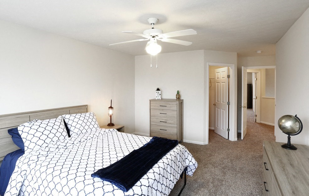 a bedroom with a bed and a ceiling fan