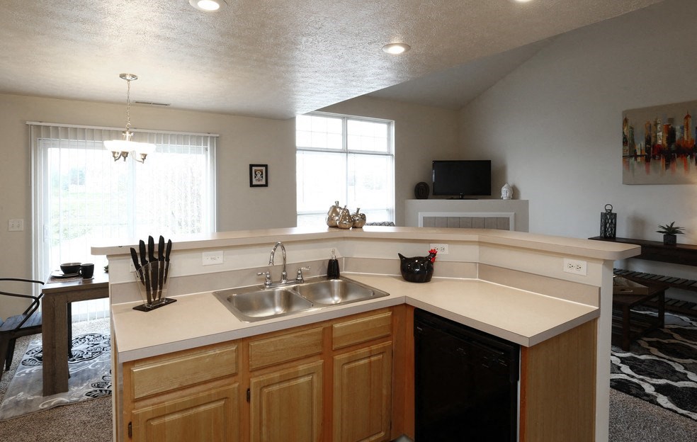 an empty kitchen with a sink and a counter top