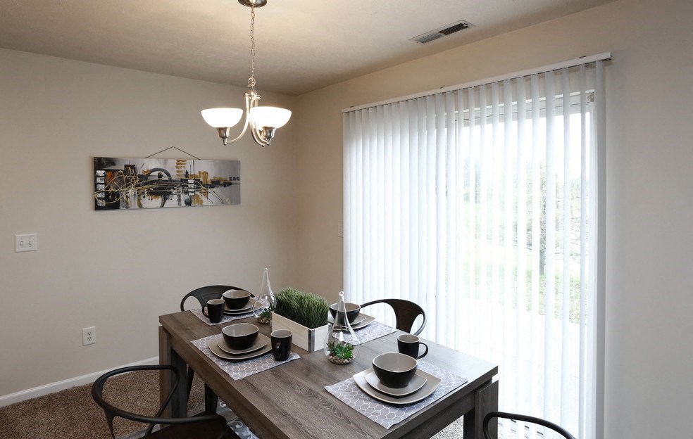 a dining room with a wooden table and a large window
