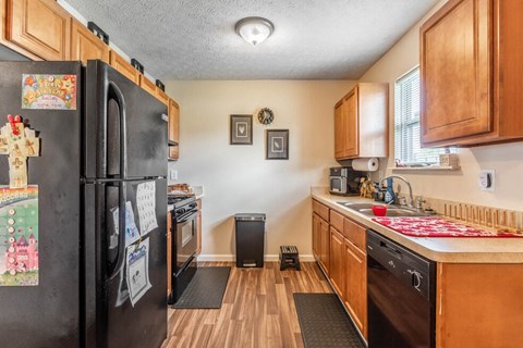 a kitchen with black appliances and wooden cabinets