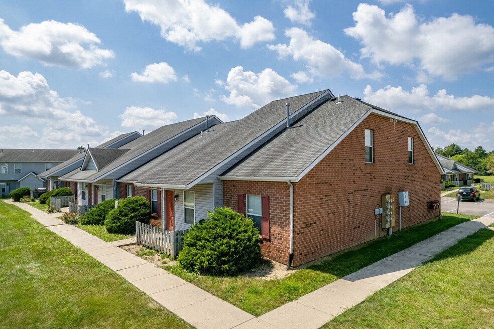 a red brick house with a sidewalk in front of it