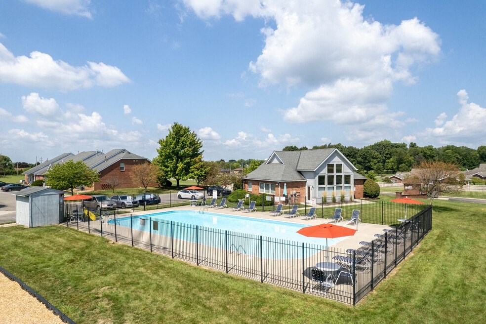 a swimming pool with a fence and a house in the background