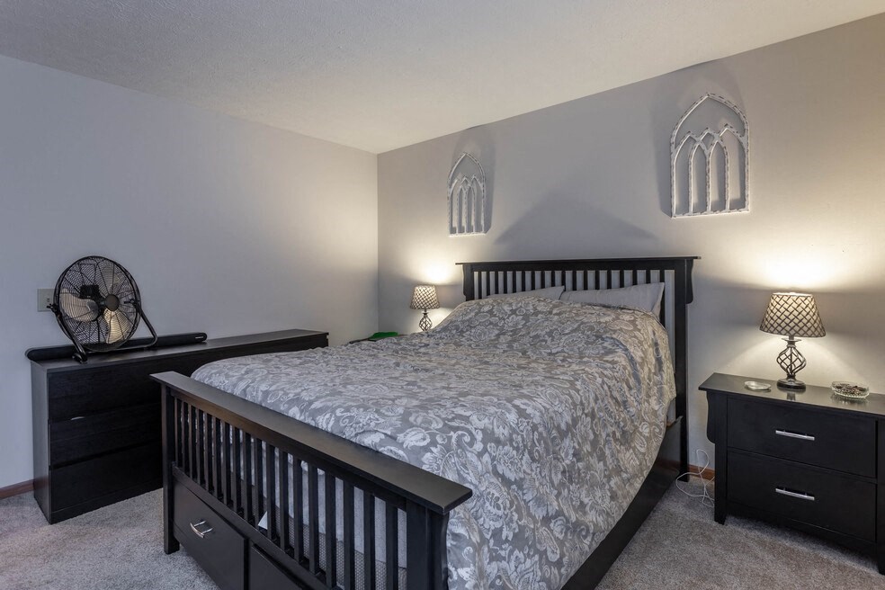 a bedroom with a bed and a gothic window