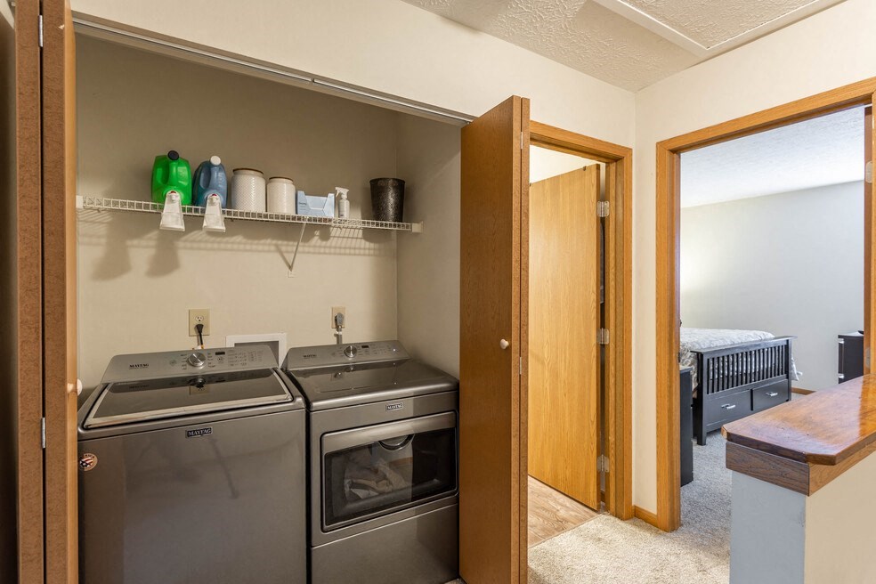 a laundry room with a washer and dryer and a door to a bedroom