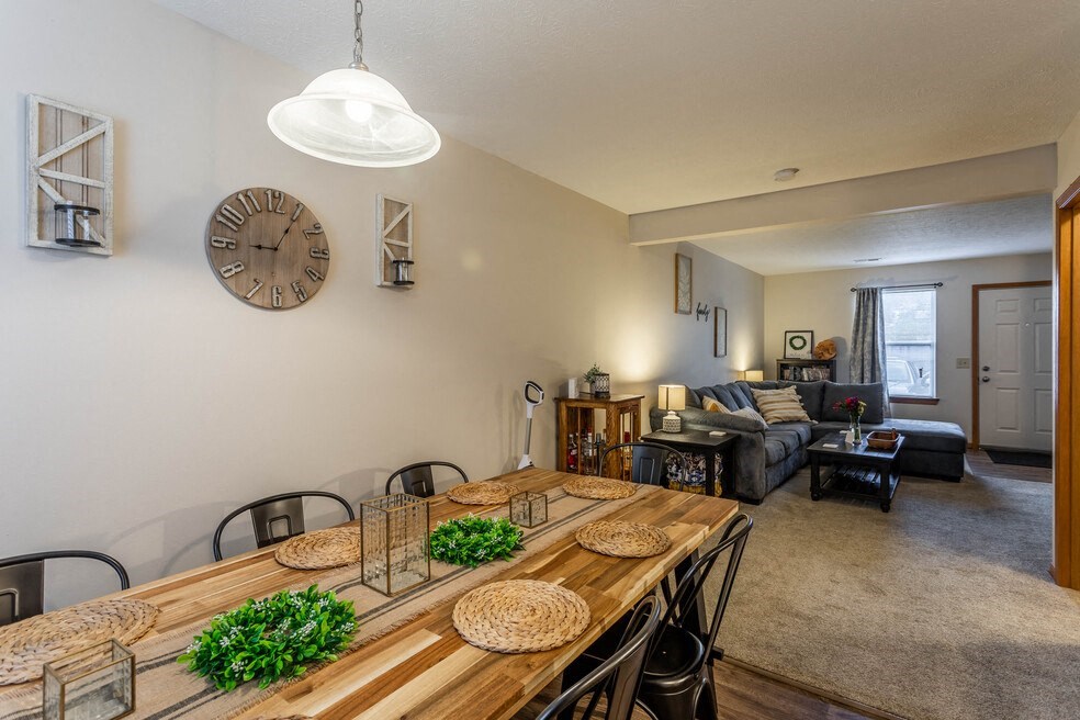 an open living room and dining room with a long wooden table