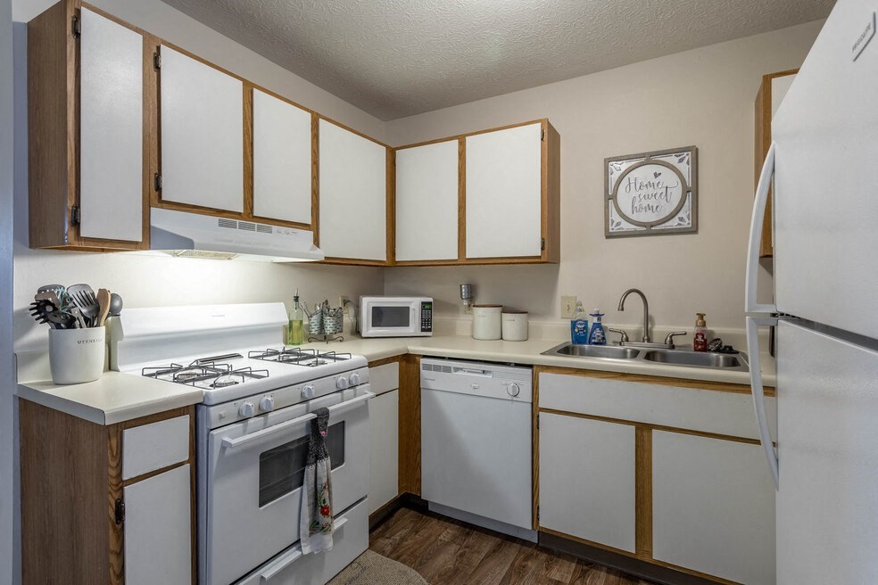 a kitchen with white appliances and wooden cabinets