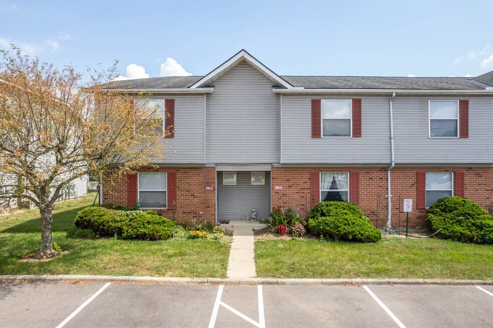 the front of a brick and with a yard and grass