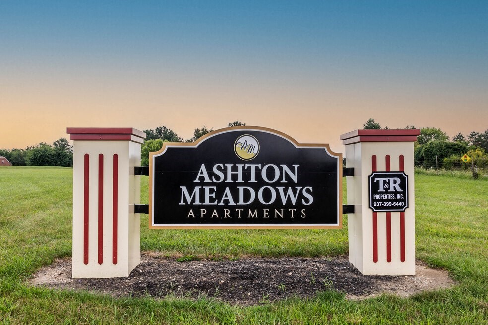 a sign for apartments in a field