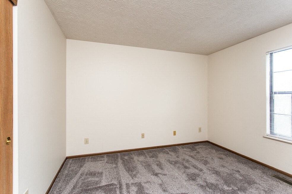 an empty room with carpet and a window