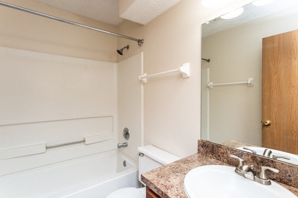 a bathroom with a sink and a tub and a mirror