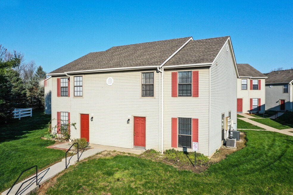 a white house with red doors and a yard