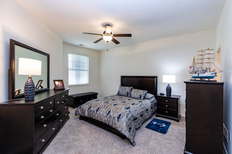 a bedroom with a bed and a ceiling fan