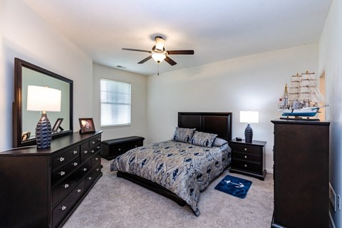 a bedroom with a bed and a ceiling fan
