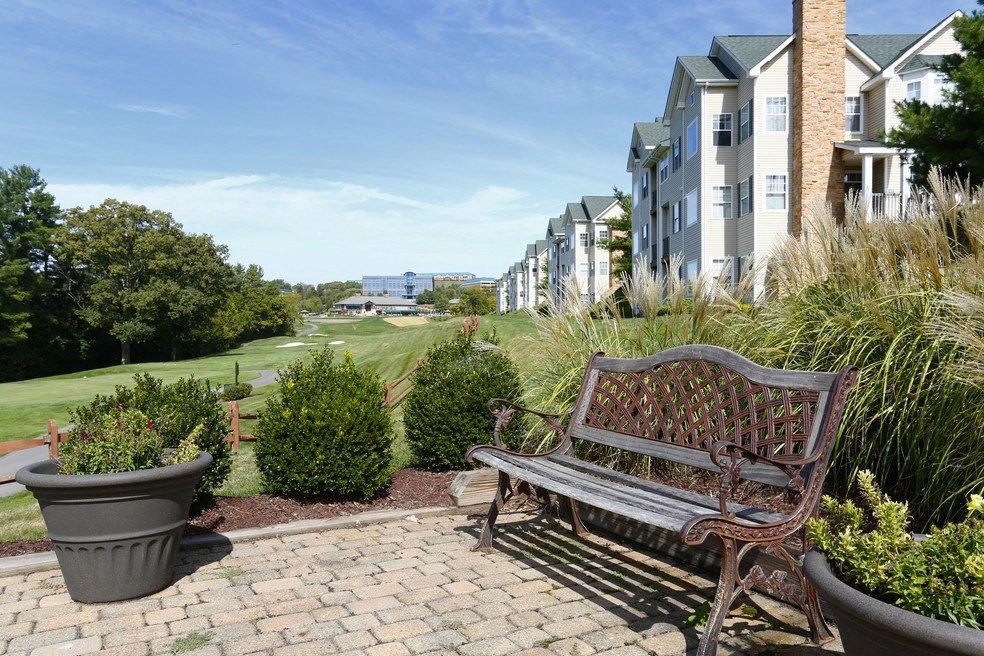 a bench sitting on a brick patio in front of a building