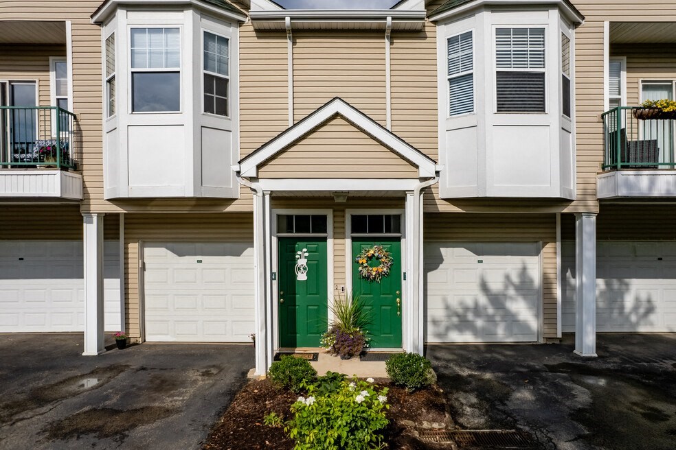 the front of an apartment building with green doors