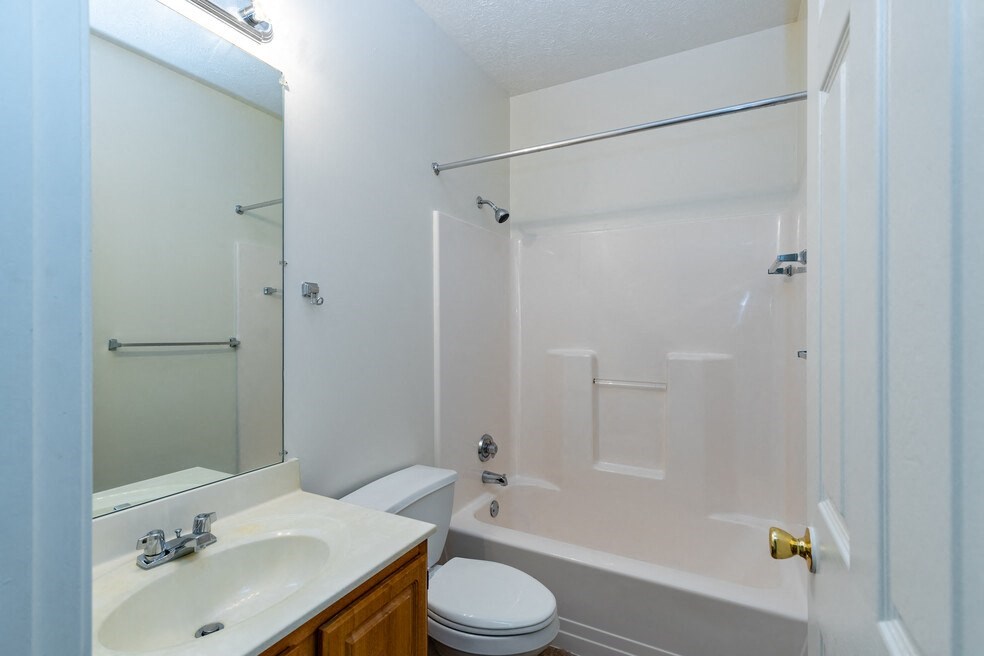 a bathroom with a shower sink and toilet and a mirror