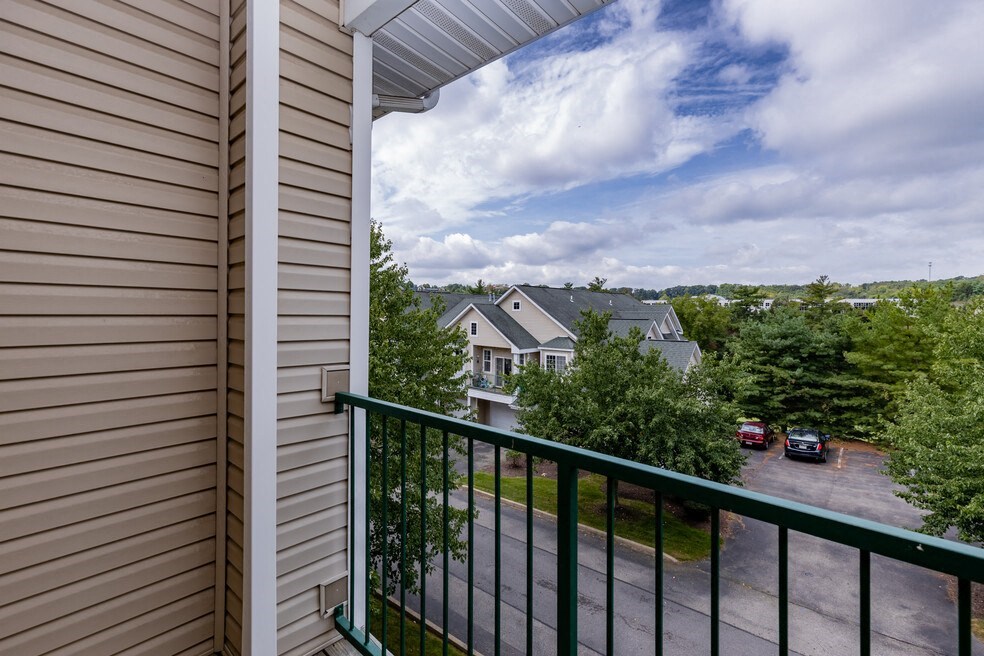 a balcony with a view of houses and a cloudy sky
