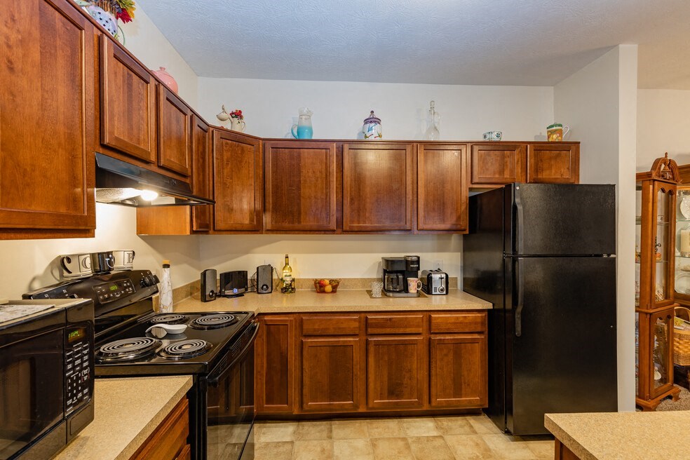 a kitchen with black appliances and wooden cabinets