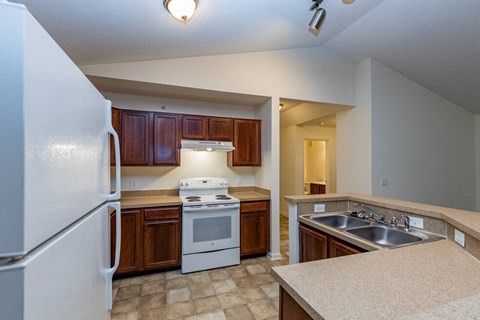 a kitchen with white appliances and wooden cabinets