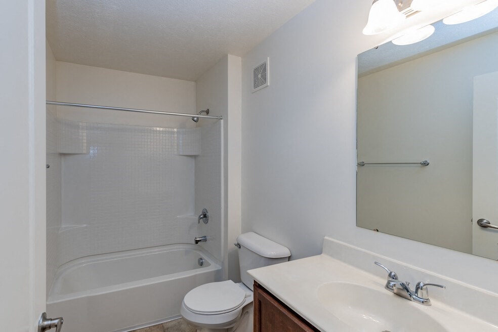 a bathroom with a shower sink and toilet and a mirror