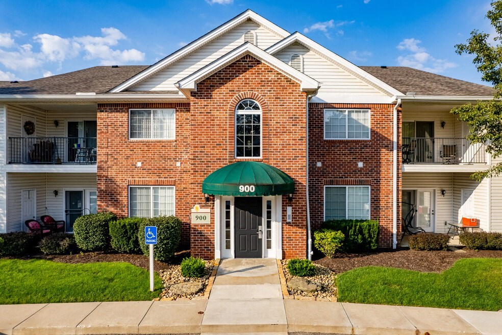 the front of a brick house with a green roof and a blue mailbox