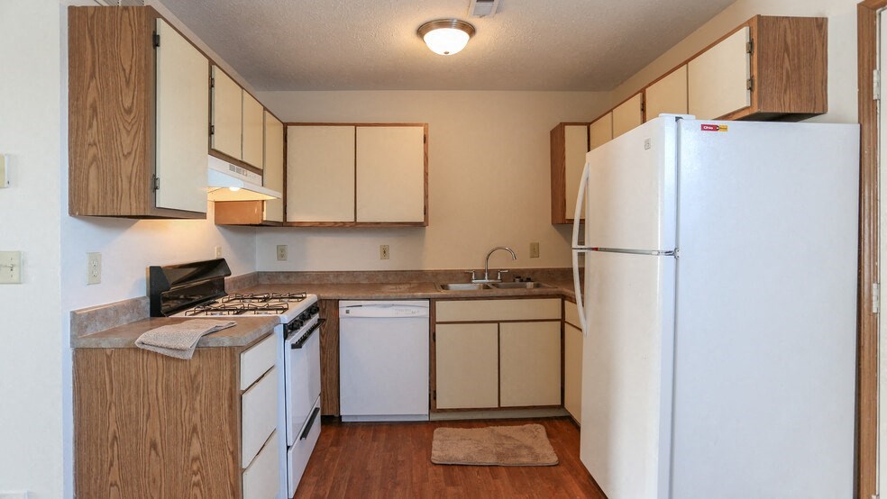 a kitchen with white appliances and a refrigerator