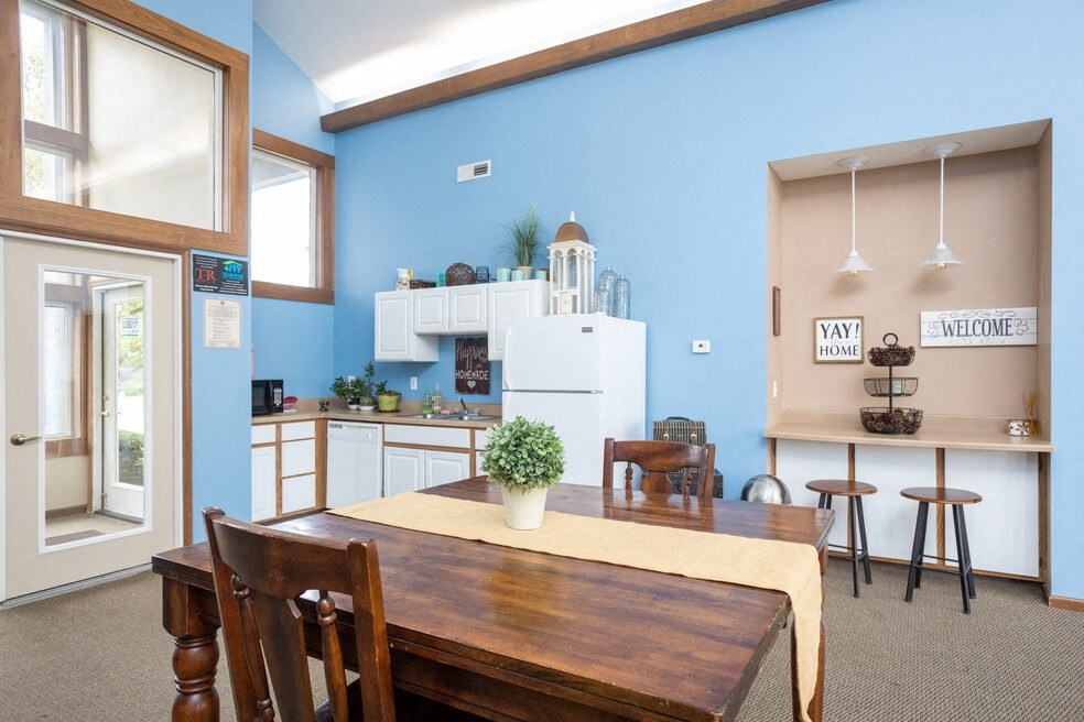 a dining room and kitchen with a table and chairs