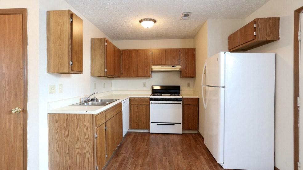 a kitchen with white appliances and wooden cabinets
