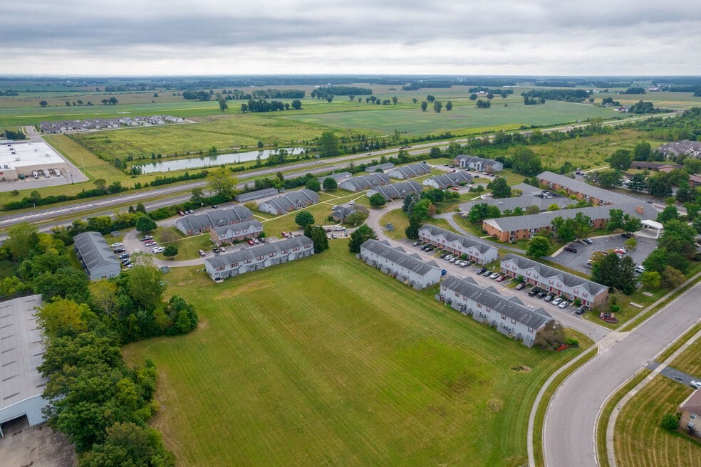 an aerial view of a neighborhood with houses and a grass field