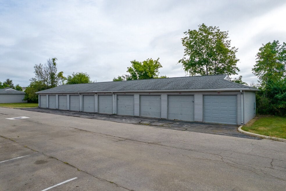 a long garage with white doors and a gray roof