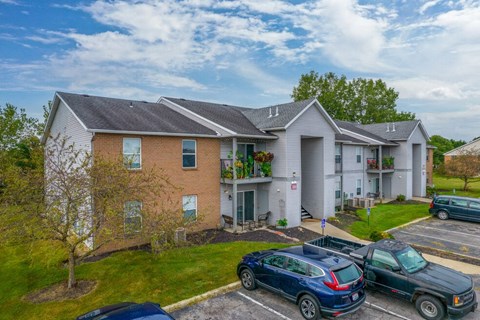 a condo building with cars parked in front of it