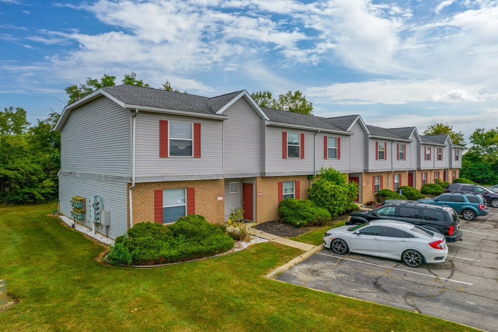 a row of houses with cars parked in front of them