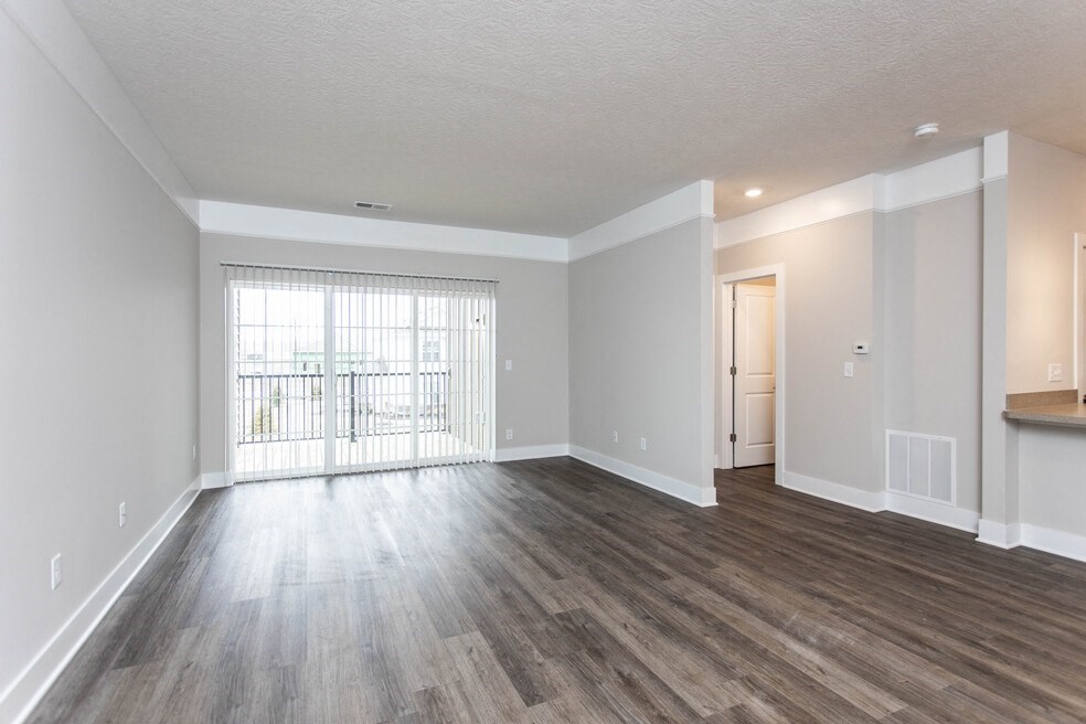 the living room and dining room of an apartment with wood flooring