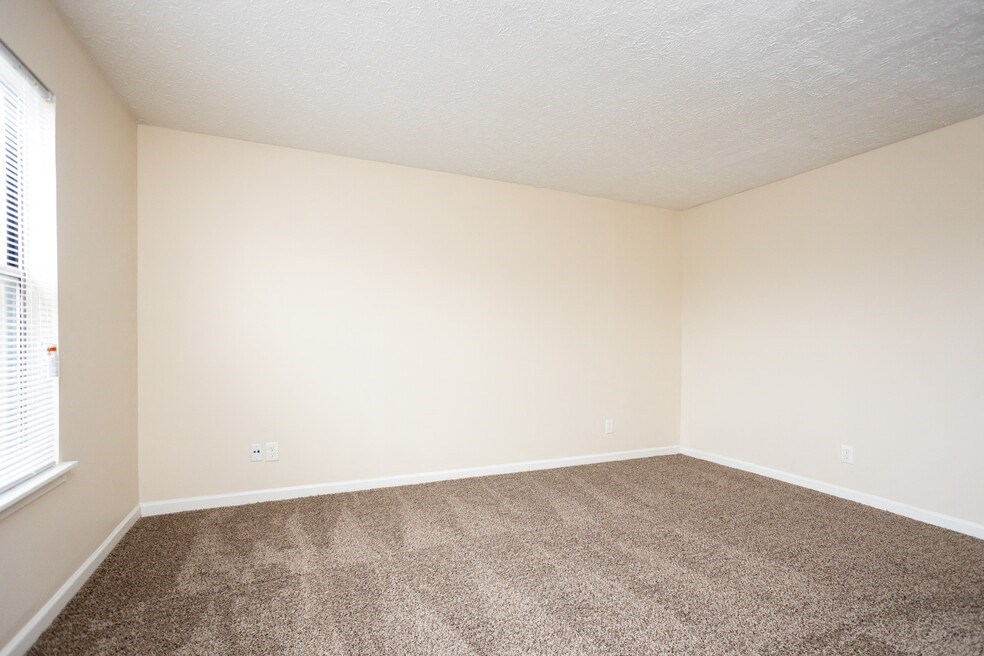 an empty room with carpet and a window