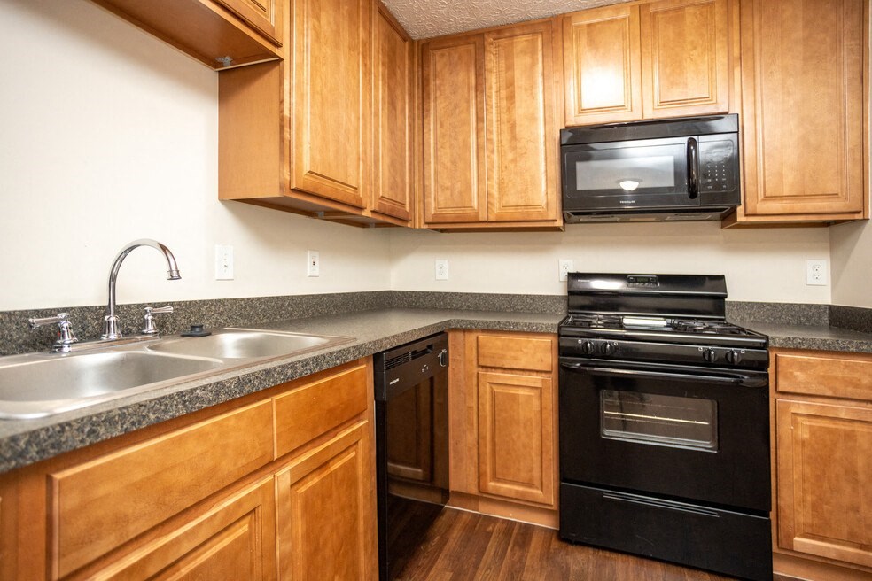 a kitchen with black appliances and wooden cabinets