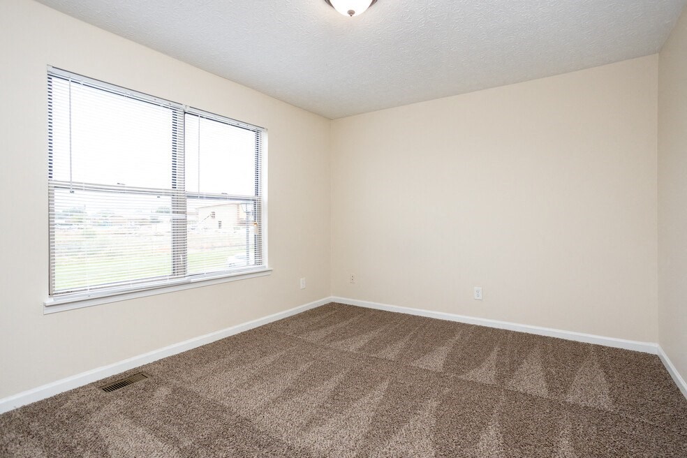an empty room with carpet and a window