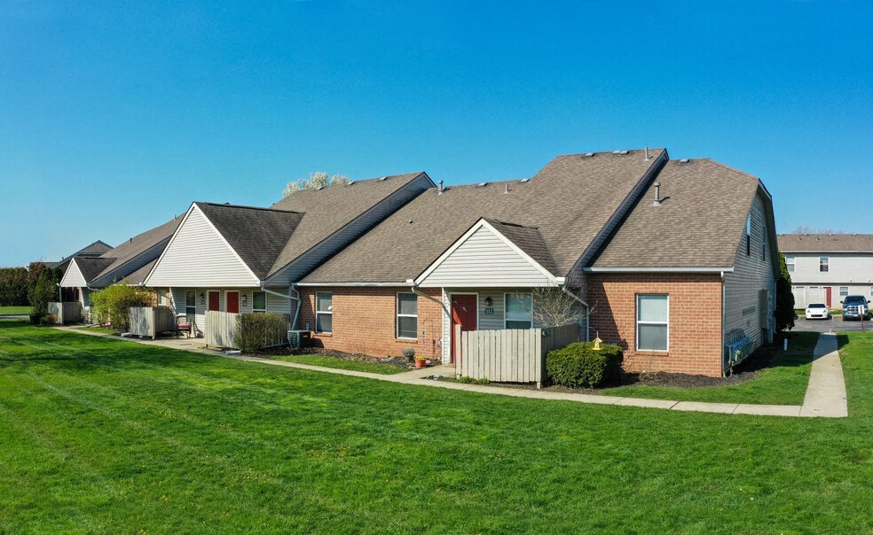 a row of houses in a neighborhood with green grass