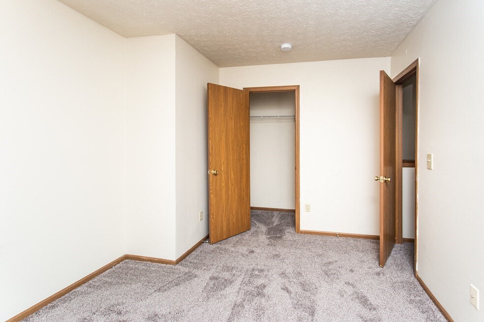 an empty room with two doors and a closet