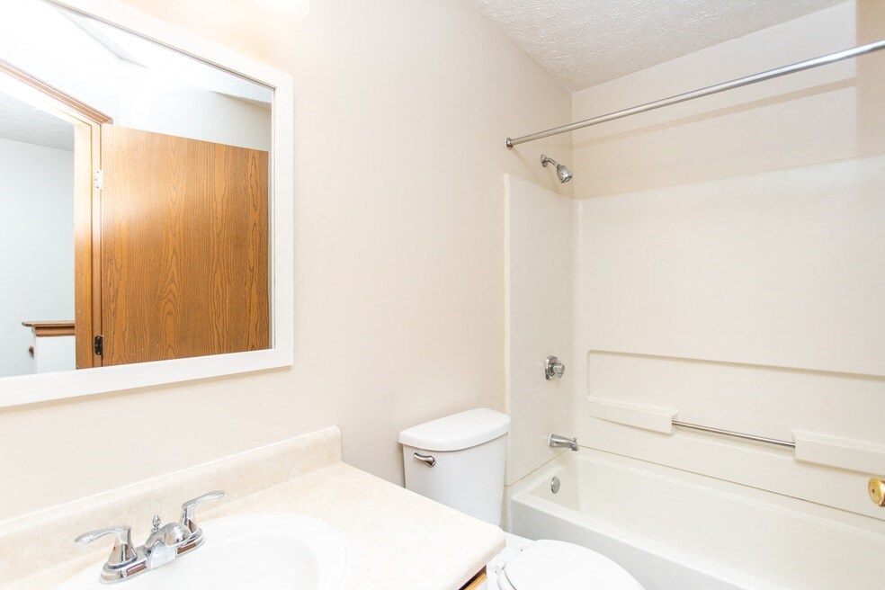 a bathroom with a mirror and a toilet and a tub