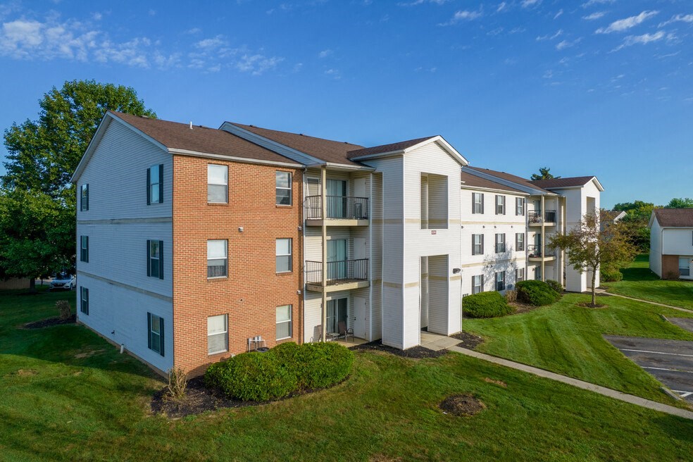 an aerial view of an apartment building with green grass and trees